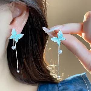 Elegant butterfly tassel earrings with light blue glass wings and pearls for women