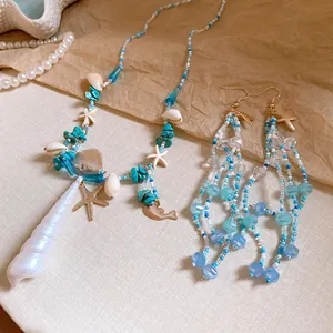 Detail view of beach style beaded necklace and earrings with starfish and shell