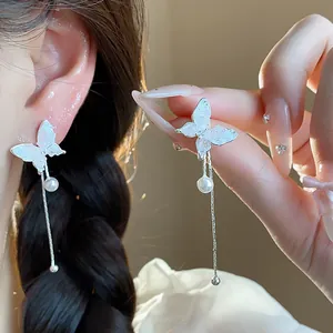 Detailed close-up of elegant silver butterfly tassel earrings featuring white pearls