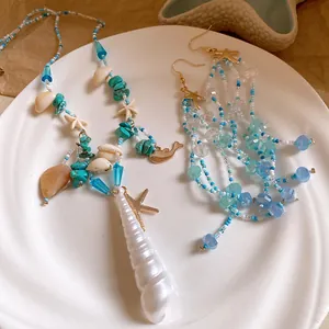 Macro view of summer beach style starfish and shell beaded necklace with matching earrings.