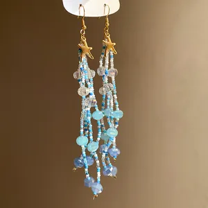 Detailed view of handmade starfish beaded dangle earrings with blue sea-inspired beads.