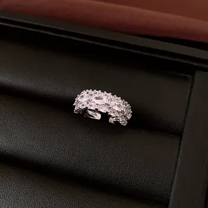 Macro detail view of a luxury silver-toned ring with sparkling floral rhinestone settings