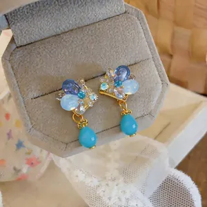 Close-up of vintage French-style blue crystal teardrop clip-on earrings in jewelry box