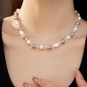 Primo piano di una collana di cristallo e perle argentate e bianche su una modella.