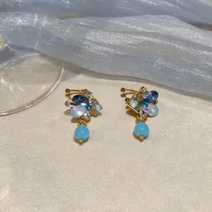 Macro view of French vintage rhombic ear clips with blue crystals and drop beads