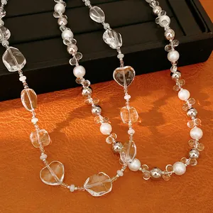 Dettaglio di perle di cristallo a forma di cuore su una collana elegante.