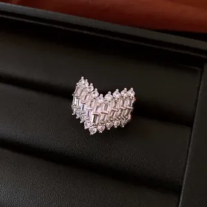 Macro detail of a sparkling heart shaped ring with baguette crystals on black box