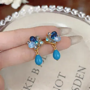 Close-up of vintage French blue crystal drop ear clips with diamond-shaped setting.