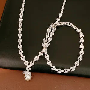 Détail d'un ensemble élégant de collier et bracelet en zircon avec pendentif perle.