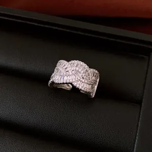 Close-up of an elegant silver-colored ring with sparkling baguette and round stones.