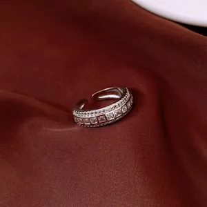 Close-up of silver-finish ring with clear square rhinestones on red fabric