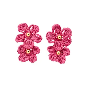 Bold and vibrant pink handmade raffia flower earrings featuring gold bead centers.