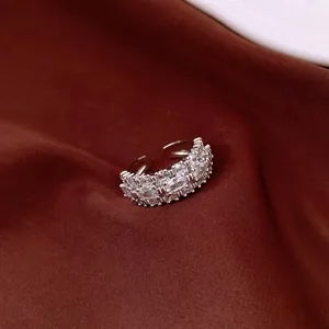 Detailed macro shot of an elegant silver tiered ring with sparkling clear rhinestones on fabric