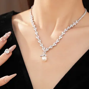 Gros plan d'un collier élégant en zircon avec un pendentif central en perle blanche