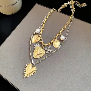 Vintage layered gold and silver heart necklace with elegant pearls and crystal charms.