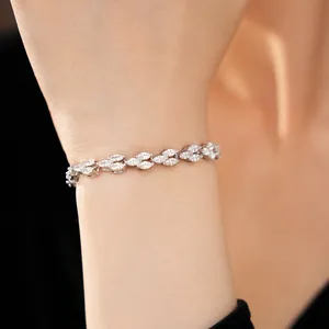 Détail rapproché d'un élégant bracelet argenté orné de pierres blanches taille marquise au poignet