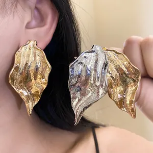 Detailed close-up of metallic crumpled leaf earrings showing elegant gold and silver finishes