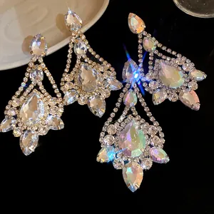Macro detail of elegant silver needle drop earrings with pear-cut sparkling rhinestones.