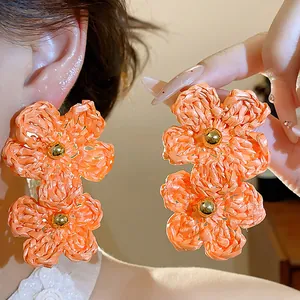 Handmade orange raffia woven double flower drop earrings for a vibrant summer resort look