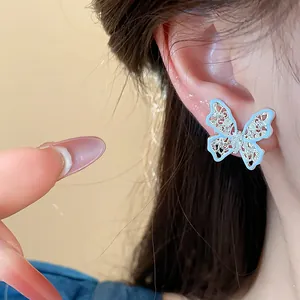 Dettaglio ravvicinato di un elegante orecchino a farfalla traforato azzurro con zirconi.
