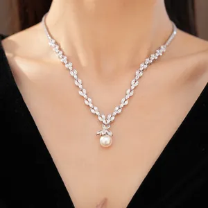 Gros plan d'un collier en zircon orné d'un élégant pendentif en perle blanche