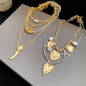 Detail view of double-layered vintage necklaces featuring gold heart and horn pendants
