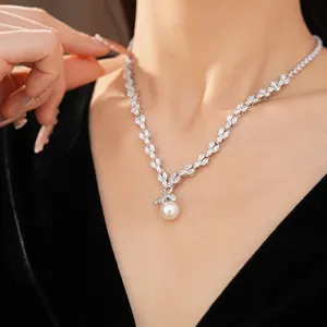 Gros plan d'un collier en zircon étincelant avec un élégant pendentif perle blanche