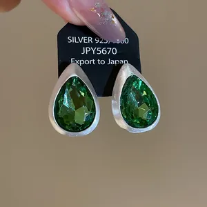 Vintage water-drop earrings with green faceted gemstones and brushed silver finish
