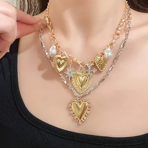 Detail view of a vintage double-layered metal necklace with heart and pearl pendants