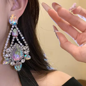 Close-up detail of oversized iridescent teardrop rhinestone drop earrings with silver needle
