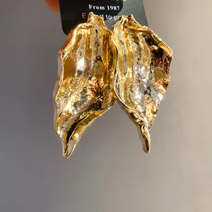 Close-up detail showing the unique hammered texture of these gold wrinkled leaf earrings.