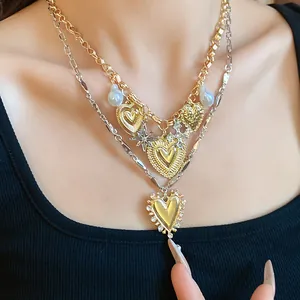 Detailed macro shot of a double-layered vintage heart necklace with rhinestones and pearls.