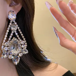 Close-up detail of sparkling rhinestone water drop chandelier earrings on model