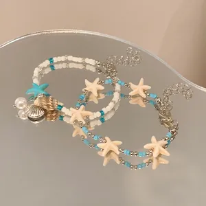 Close-up detail of ocean-themed beaded bracelets with starfish and shell charms