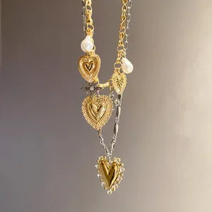 Detailed macro view of a vintage double-layer gold and silver heart necklace with pearls