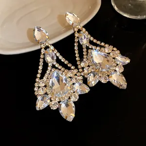 Detail shot of sparkling crystal teardrop chandelier earrings in gold-toned setting