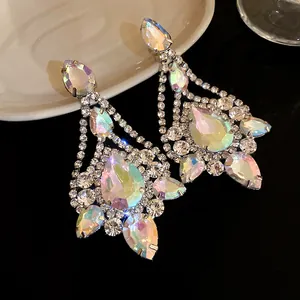 Close-up of iridescent teardrop crystal earrings with shimmering rhinestone detail.