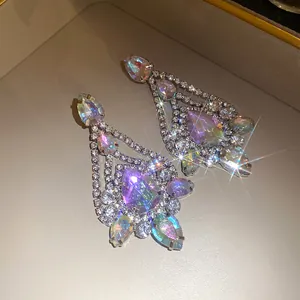 Close-up of sparkling iridescent teardrop dangle earrings with shiny rhinestones.
