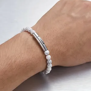 Primo piano dettagliato di perline in marmo bianco e chiusura a scatto in acciaio al polso.