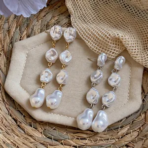 Eleganti orecchini pendenti con perle barocche irregolari in finitura oro e argento.