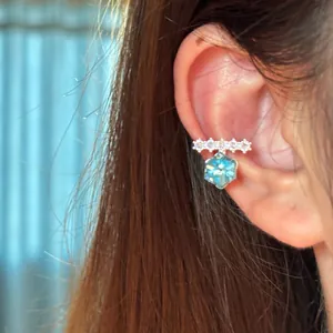 Detail view of a sparkling zircon ear cuff featuring a blue hexagonal crystal pendant