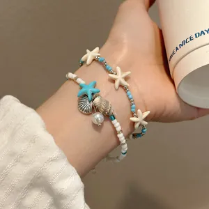 Detailed view of ocean-themed beaded bracelets with starfish, shell, and pearl charms