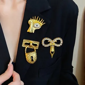 Set of three vintage luxury gold brooches with zircons pinned on a black blazer lapel