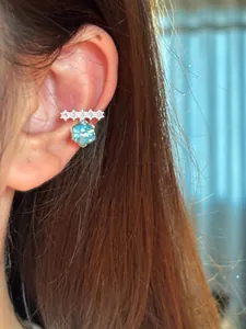 Detail shot of elegant silver-toned ear cuff with hexagonal blue zircon and clear stones