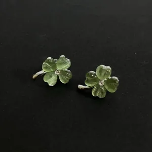 Macro view of green cat's eye stone flower earrings with a small center rhinestone
