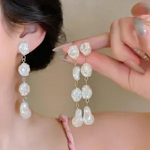 Dettaglio ravvicinato di orecchini pendenti eleganti con perle barocche irregolari