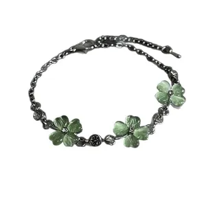 Elegant silver bracelet featuring green cat-eye clover charms and sparkling crystals