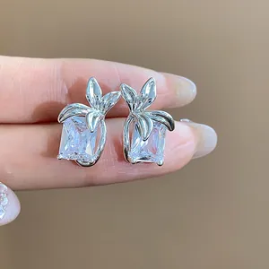 Vista macro dettagliata di eleganti orecchini a lobo in argento con zircone quadrato