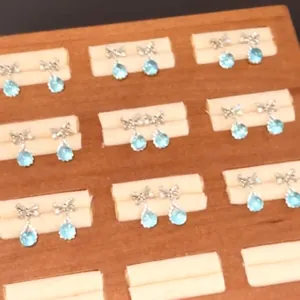 Detailed view of bow-knot earrings with aquamarine teardrop zircons on display