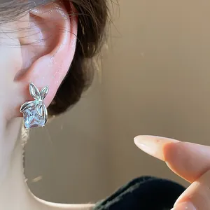 Primo piano di orecchini a lobo a fiore in zircone quadrato con finitura argento lucido